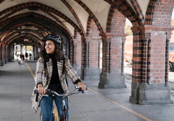 Happy woman riding bicycle in the city, Berlin, Germany model released Symbolfoto  AHSF01226