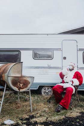 Santa claus preparing a barbecue in front of a camper model released Symbolfoto  DAMF00197