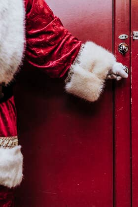 Santa Claus gloved hands open the door, close up model released Symbolfoto  DAMF00200