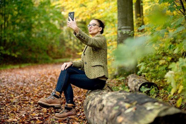 IMAGO Creative: Internationaler Frauenmonat, Gesundheit, Frauen in der Menopause Mature woman taking a selfie in a autumn forest model released Symbolfoto  FLLF00353