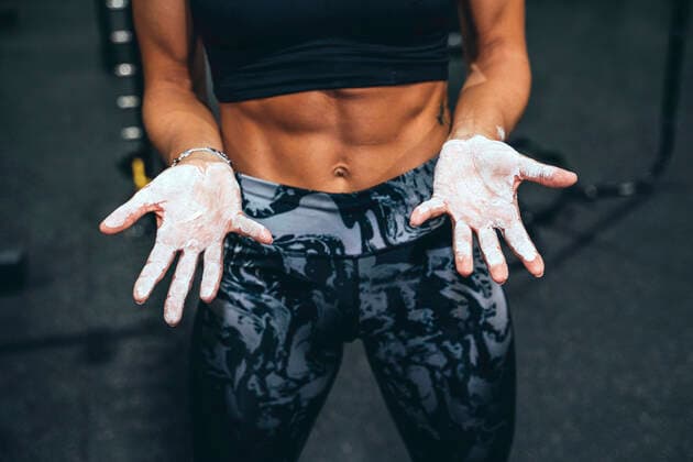 Woman in good shape showing hands covered with chalk model released Symbolfoto  JCMF00269