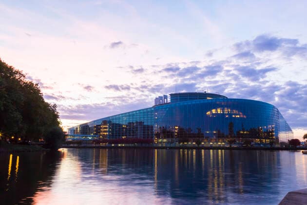 Louise Weiss building by river against sky at sunset, Strasbourg, France  JUNF01732