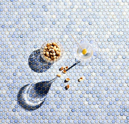 Directly above shot of pistachios and martini glass on blue patterned background  KSWF02072