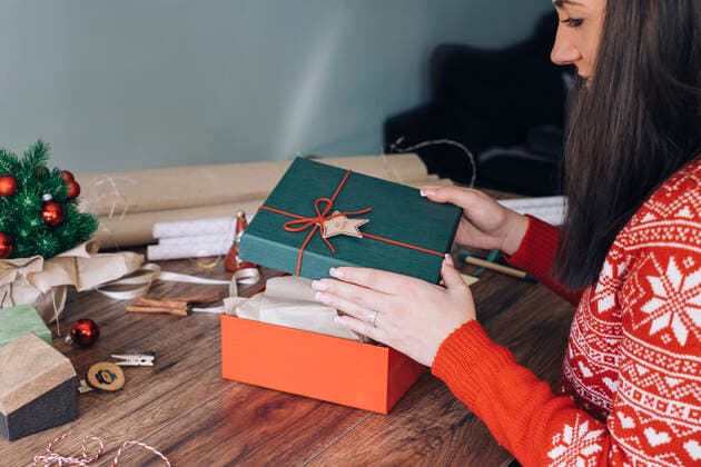 Woman s hands decorating Christmas present model released Symbolfoto  MOMF00795