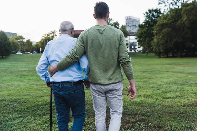 Back view of young man assisting his grandfather walking model released Symbolfoto  UUF19344