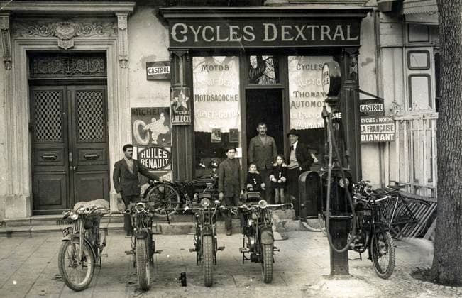 CYCLISME annees 20 Devanture d un magasin de cycles et de motos. Photographie anonyme pour une carte postale vers 1920. Credit : Collection IM KHARBINE-TAPABOR. *** CYCLING in the 20s Front of a bicycle and motorcycle shop Anonymous photograph for a postcard around 1920 Credit Collection IM KHARBINE TAPABOR  KH177073