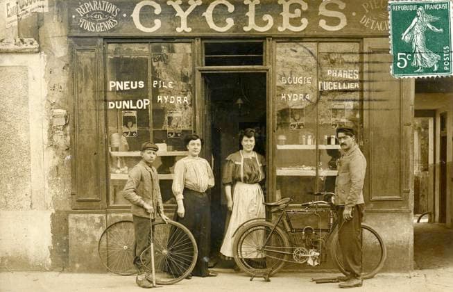 CYCLES annees 1900 Devanture d un magasin de cycles. Photographie anonyme pour une carte postale vers 1909. Credit : Collection IM KHARBINE-TAPABOR *** CYCLES 1900s Front of a bicycle shop Anonymous photograph for a postcard around 1909 Credit Collection IM KHARBINE TAPABOR  KH178402