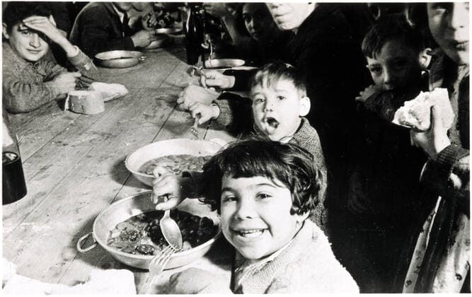 Guerre d Espagne Les petits enfants refugies (parce que republicains) non moins joyeux mangent a cote de leurs peres dans le stade de Barcelone pendant la guerre d Espagne vers 1937. Carte postale editee par le Comisariat de Propaganda de la Generalitat de Catalunya. Credit: Collection IM KHARBINE-TAPABOR. *** War of Spain The little children refugees because republicans no less joyful eat next to their fathers in the Barcelona stadium during the Spanish War around 1937 Postcard published by the Comisariat de Propaganda de la Generalitat de Catalunya Credit Collection IM KHARBINE TAPABOR  KH50104