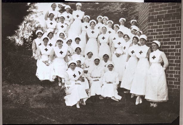 Negative - Group of Red Cross Workers, Victoria, 1914 or later, Black and white copy negative depicting women wearing Red Cross aprons. It is not known if they were working as nurses or in other roles for the Red Cross such as Voluntary Aid Detachments. The original image belonged to Betty Anderson of Kew. Betty (Elizabeth) was the daughter of James Caldwell Anderson and Mary Lloyd Anderson, and grand-daughter of renowned architect Lloyd Tayler. Born  Copyright Artokoloro LC190917_112395