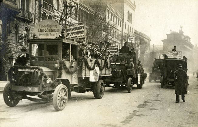 REVOLUTION ALLEMANDE Camions pavoises dans Berlin transportant une fanfare. Pour le gouvernement EBERT-SCHEIDEMANN contre la terreur. Photographie anonyme pour une carte postale de 1919. Credit : Collection IM KHARBINE-TAPABOR.