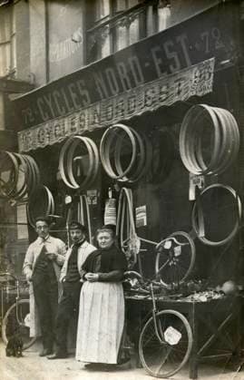 CYCLISME annees 10 Devanture d un magasin de cycles, avec etalage de pneus. Photographie anonyme pour une carte postale vers 1910. Credit : Collection IM KHARBINE-TAPABOR. *** CYCLING in the 10s Front of a bicycle shop, with tire calibration Anonymous photograph for a postcard around 1910 Credit Collection IM KHARBINE TAPABOR  KH177085