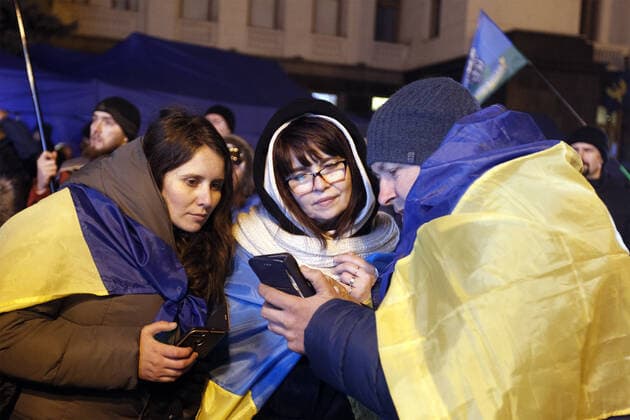 December 10, 2019, Kiev, Ukraine: Ukrainians watch on a smartphone news about the Normandy Four leaders summit, Volodymyr Zelensky, Vladimir Putin, Angela Merkel and Emmanuel Macron outside the Presidential Office in Kiev..A Normandy Format summit with the participation of leaders of Ukraine, Russia, France and Germany regarding the conflicts in eastern Ukraine was held in Paris. Kiev Ukraine - ZUMAs197 20191210_zaa_s197_010 Copyright: xPavloxGoncharx