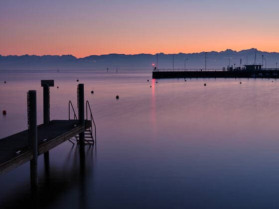 Beach on Lake Constance with view to alps Beach on Lake Constance at Wasserburg with a view of the Alps and blue sky in Bavaria, Germany after sunset Wasserburg at Bodensee Bavaria Germany