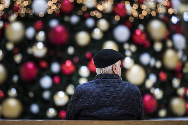 Ein Mann sitzt allein auf einer Bank vor einem geschmueckten Weihnachtsbaum in Berlin, 17.12.2019. Berlin Deutschland