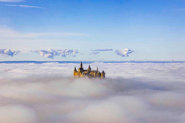 DEU; Deutschland, Baden-Württemberg, Bisingen, 10.11.2019: Burg Hohenzollern erhebt sich aus dem Nebelmeer. Auf den Bergen der Schwäbischen Alb scheint die Sonne, drunten im Tal herrscht dichter Nebel. Am Horizont das Schwarzwald Panorma.