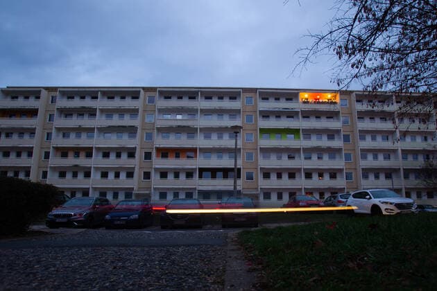 Einsam in der obersten Etage Auf der Käthe-Kollwitz-Straße im sächsischen Heidenau bei Dresden ist eine letzte Wohnung in einem Plattenbaublock noch bewohnt. Rund um den beleuchteten Balkon, sind bereits alle Mieter ausgezogen. Heidenau Sachsen Deutschland