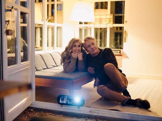 IMAGO Creative, Weihnachten, Tradition: Weihnachtsfilme sehen Senior couple watching a movie with a video projector at home at night model released Symbolfoto property released  GUSF02976