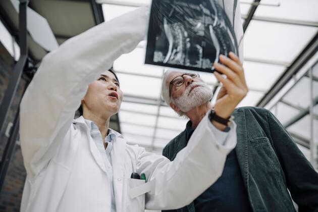 Female doctor discussing x-ray with senior patient model released Symbolfoto property released  JOSF04022