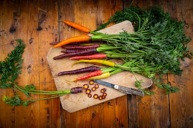Penknife and fresh colorful carrots lying on cutting board  LVF08370
