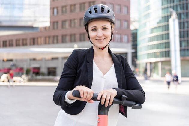 Portrait of smiling woman with e-scooter in the city, Berlin, Germany model released Symbolfoto  WPEF02359
