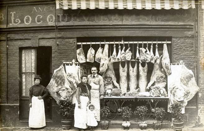 BOUCHERIE annees 10 Devanture d une boucherie avec carcasses d animaux suspendues. Photographie anonyme pour une carte postale vers 1910. Credit : Collection IM KHARBINE-TAPABOR *** Butchery years 10 Front of a butcher shop with hanging animal carcasses Anonymous photograph for a postcard around 1910 Credit Collection IM KHARBINE TAPABOR  KH179085