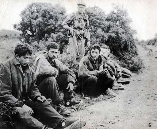 GUERRE D ALGERIE Groupe de prisonniers algeriens encadres par des militaires francais. Photographie anonyme vers 1958 pour la propagande francaise. Credit : Collection IM Kharbine-Tapabor. *** ALGERIAN WAR Group of Algerian prisoners framed by French soldiers Anonymous photograph around 1958 for French propaganda Credit Collection IM Kharbine Tapabor  KH202428
