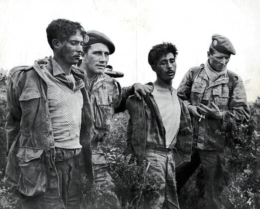 GUERRE D ALGERIE Groupe de prisonniers algeriens encadres par des militaires francais. Photographie anonyme vers 1958 pour la propagande francaise. Credit : Collection IM Kharbine-Tapabor. *** ALGERIAN WAR Group of Algerian prisoners framed by French soldiers Anonymous photograph around 1958 for French propaganda Credit Collection IM Kharbine Tapabor  KH202430