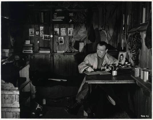 POLE SUD Scott ecricant son livre de bord. Photographie du film Scott of the Antartic (L aventure sans retour) realise en 1948 par Charles FREND (1909-1977) avec John MILLS (1908-2005) d apres le voyage d exploration au Pole Sud de SCOTT (1868-1912). Credit : Collection Jonas Kharbine-Tapabor.