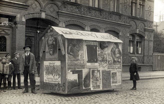ALLEMAGNE annees 10 Barraque de propagande tapissee d affiches politiques pour le SPD. Carte postale vers 1910. Credit : IM KHARBINE-TAPABOR.