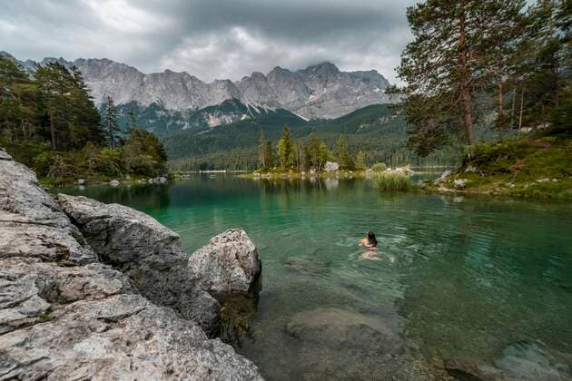  Frau schwimmt im See, Blick auf Eibsee vor Zugspitzmassiv mit Zugspitze, wolkenverhangen, Wettersteingebirge, bei Grainau, Oberbayern, Bayern, Deutschland, Europa *** Woman swimming in the lake, view of Eibsee in front of Zugspitze massif with Zugspitze, cloudy, Wettersteingebirge, near Grainau, Upper Bavaria, Bavaria, Germany, Europe Copyright: imageBROKER/MoritzxWolf ibxmmw05092181.jpg
