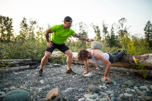 Personal trainer uses boulders to push a client toward goals. Chilliwack, British Columbia, Canada CR_JDIP191112-209909-01