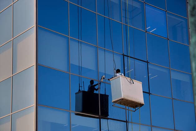 IMAGO Creative: Dichotomien, Reflexionen - Architektur Worker cleaning the windows in a modern glass building, Pamplona Spain Pamplona, Navarra, Spain ,editorial use only CR_KAJO191116-241589-01