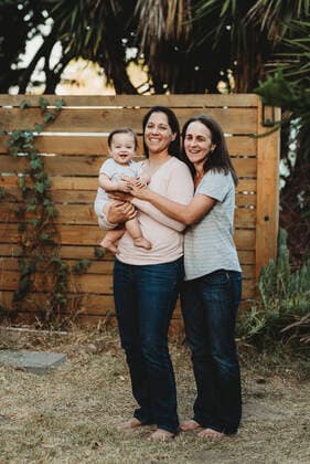 Laughing baby with two teeth in backyard with two barefoot moms La Mesa, CA, USA CR_KESM191114A-213406-01