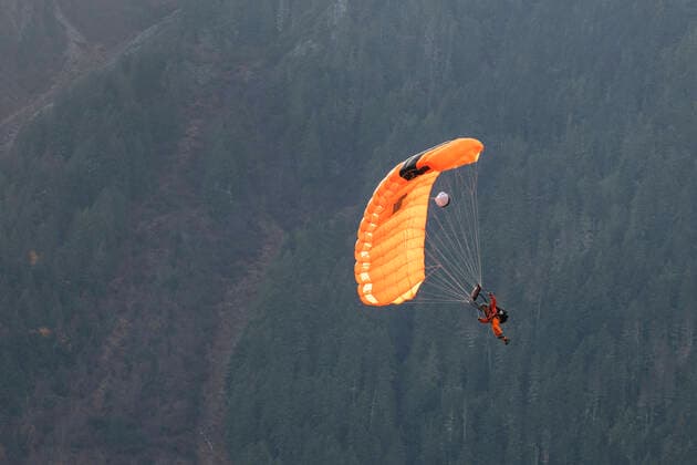 IMAGO Creative: Sport Dichotomien - Land und Wasser A paratrooper from the Canada Search and Rescue fly in surrounded by mountains and land on the grass at the Pemberton airport during a training mission. Pemberton, British Columbia, Canada ,editorial use only CR_PSFZ191113-232550-01