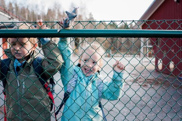 kids looking through a school fence saying goodbye to their dad Norrtälje, Sweden CR_RABE191115-238458-01