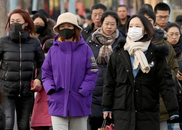 Chinese wear protective respiratory masks in downtown Beijing on Tuesday, January 21, 2020. Health authorities in China reported the country s fourth death from a new type of coronavirus, as the country braces for the Lunar New Year travel boom amid concerns over a possible outbreak similar to that of the SARS virus in the early 2000s.  PEK2020012107 STEPHENxSHAVER