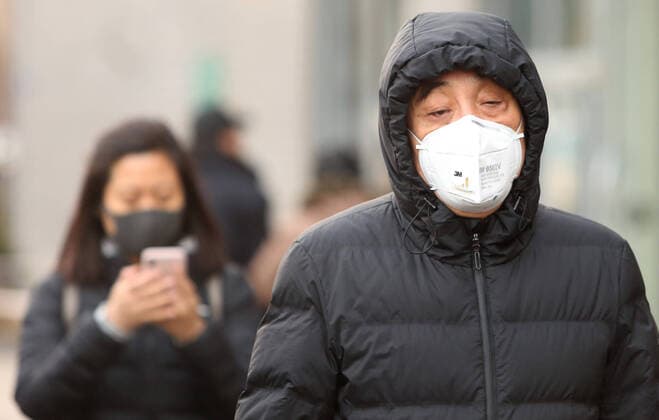 Chinese wear protective respiratory masks in downtown Beijing on Tuesday, January 21, 2020. Health authorities in China reported the country s fourth death from a new type of coronavirus, as the country braces for the Lunar New Year travel boom amid concerns over a possible outbreak similar to that of the SARS virus in the early 2000s.  PEK2020012108 STEPHENxSHAVER
