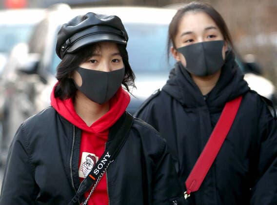 Chinese wear protective respiratory masks in downtown Beijing on Tuesday, January 21, 2020. Health authorities in China reported the country s fourth death from a new type of coronavirus, as the country braces for the Lunar New Year travel boom amid concerns over a possible outbreak similar to that of the SARS virus in the early 2000s.  PEK2020012114 STEPHENxSHAVER