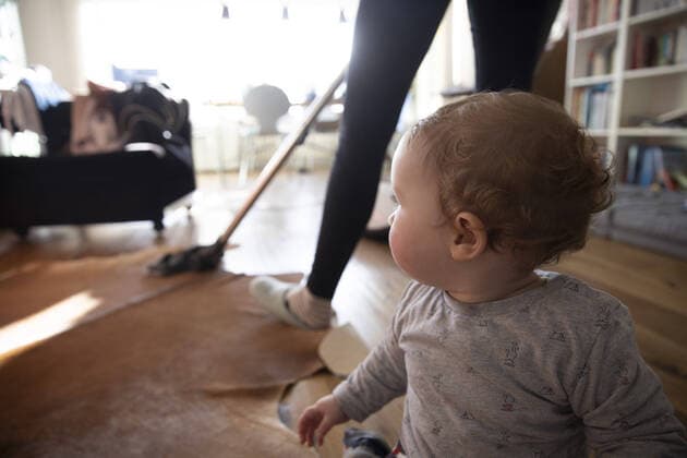 Frau saugt Staub mit einem Staubsauger in ihrem Wohnzimmer, Bonn, 19.12.2019. Woman vacuuming with a vacuum cleaner in her living room, Bonn, 19.12.2019. Bonn Deutschland