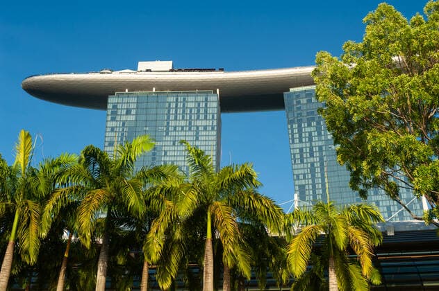 06.05.2019, Singapur, Republik Singapur, Asien - Palmen vor dem Marina Bay Sands Hotel mit seiner ikonischen Dachterrasse. *** 06 05 2019, Singapore, Republic of Singapore, Asia Palm trees in front of the Marina Bay Sands Hotel with its iconic roof terrace