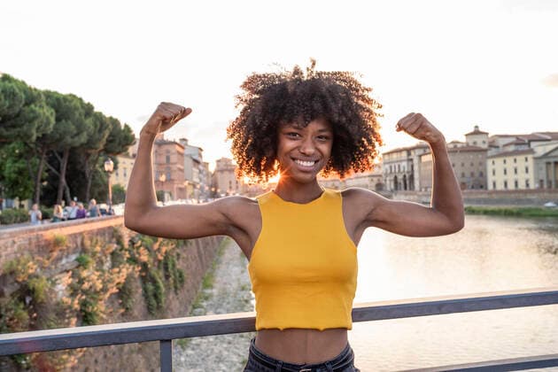 Portrait of happy young woman posing on a bridge above river Arno at sunset, Florence, Italy model released Symbolfoto  FBAF01178