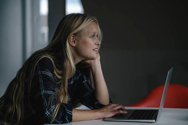 Casual young businesswoman using laptop in office model released Symbolfoto property released  GUSF03334