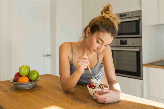 Female teenager during breakfast in the kitchen model released Symbolfoto property released  JPTF00402