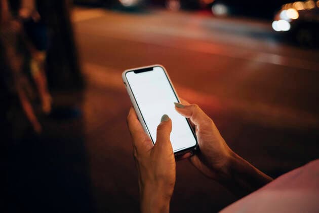 Hands of woman holding smartphone at night, close-up model released Symbolfoto  OYF00089
