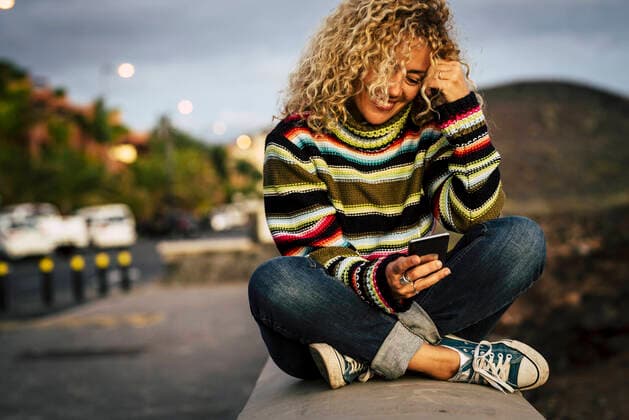 Portrait of woman wearing colorful pullover and using smartphone, Tenerife, Spain model released Symbolfoto  SIPF02106