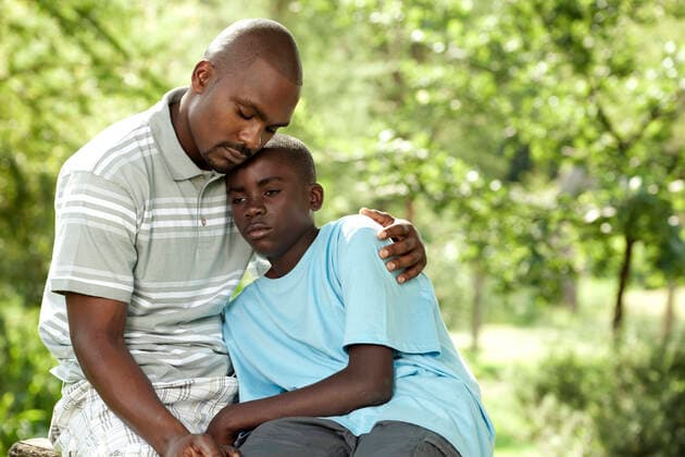 African father and son sitting outside in a garden  Copyright: xGreatstockx PE-014-0514G