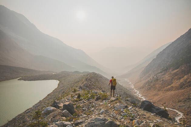 IMAGO Creative: Klimawandel - Nachhaltiges Reisen Backpacker hiking through valley filled with thick smoke. Pemberton, BC, Canada CR_JDIP200102-245515-01