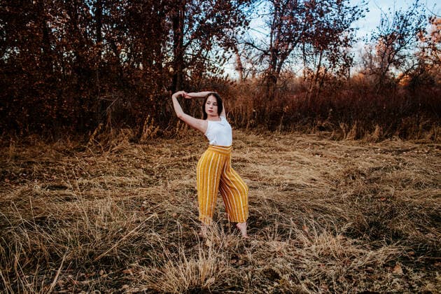 front portrait of young girl stretching in field Denver, CO, United States CR_JEMI200109F-277596-01