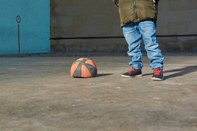 IMAGO Creative: Gesellschaft, Armut Boy with his hands in his pockets next to a deflated basketball ball. Oiz, Navarra, Espana CR_KAJO191205-248935-01