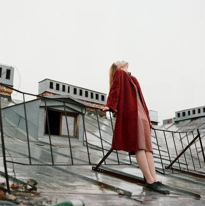 Portrait of beautiful brunette woman in red coat standing on the roof Saint Petersburg, Saint Petersburg, Russia CR_PABO200103E-264565-01
